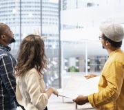 Business clients and broker salesman examining blueprints and layout